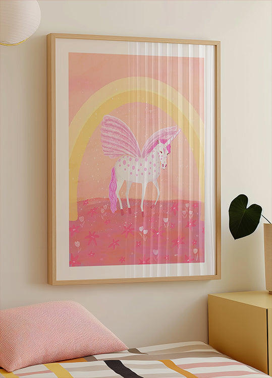 Ein gerahmtes Poster eines Einhorns mit einem rosa-weißen Farbschema vor einem rosa-gelben Hintergrund mit einem Regenbogenbogen.