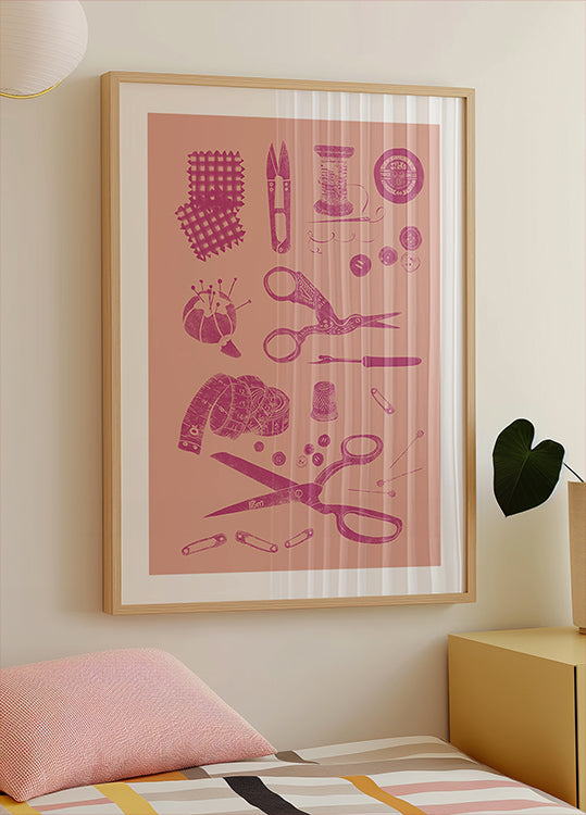 Ein gerahmtes Poster mit Näh- und Bastelwerkzeugen, darunter Scheren, Stecknadeln, Nadeln und anderen Nähartikeln, das an der Wand über einem Bett hängt.